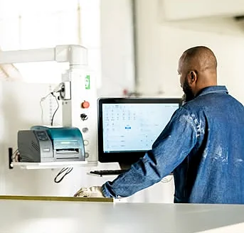 Operator programming a cut list at the saw’s control screen
